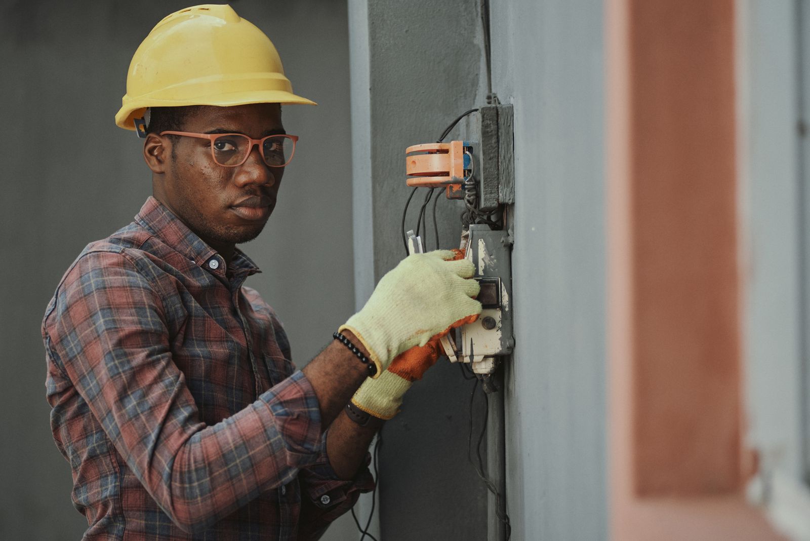 An electrician working a panel on a job